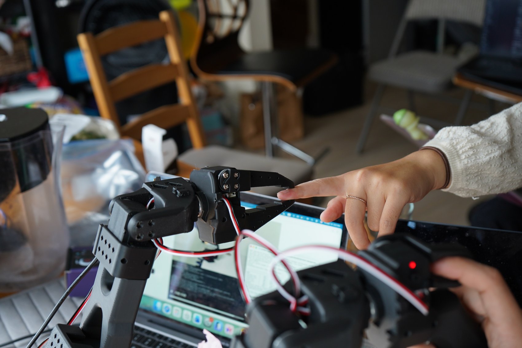 The robot arm's gripper closing on a fingertip